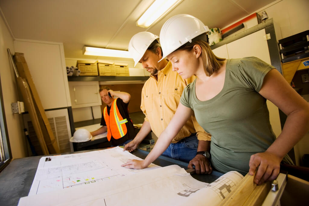 Workers Reviewing Blueprints --- Image by © Kelly Redinger/Design Pics/Corbis